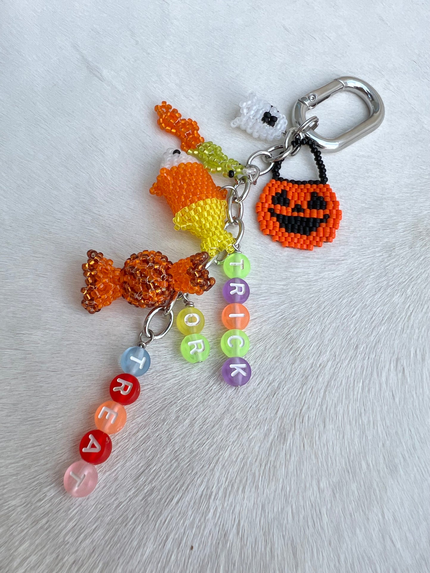 Halloween-themed keychain with candy, ghost, and pumpkin design on a white background