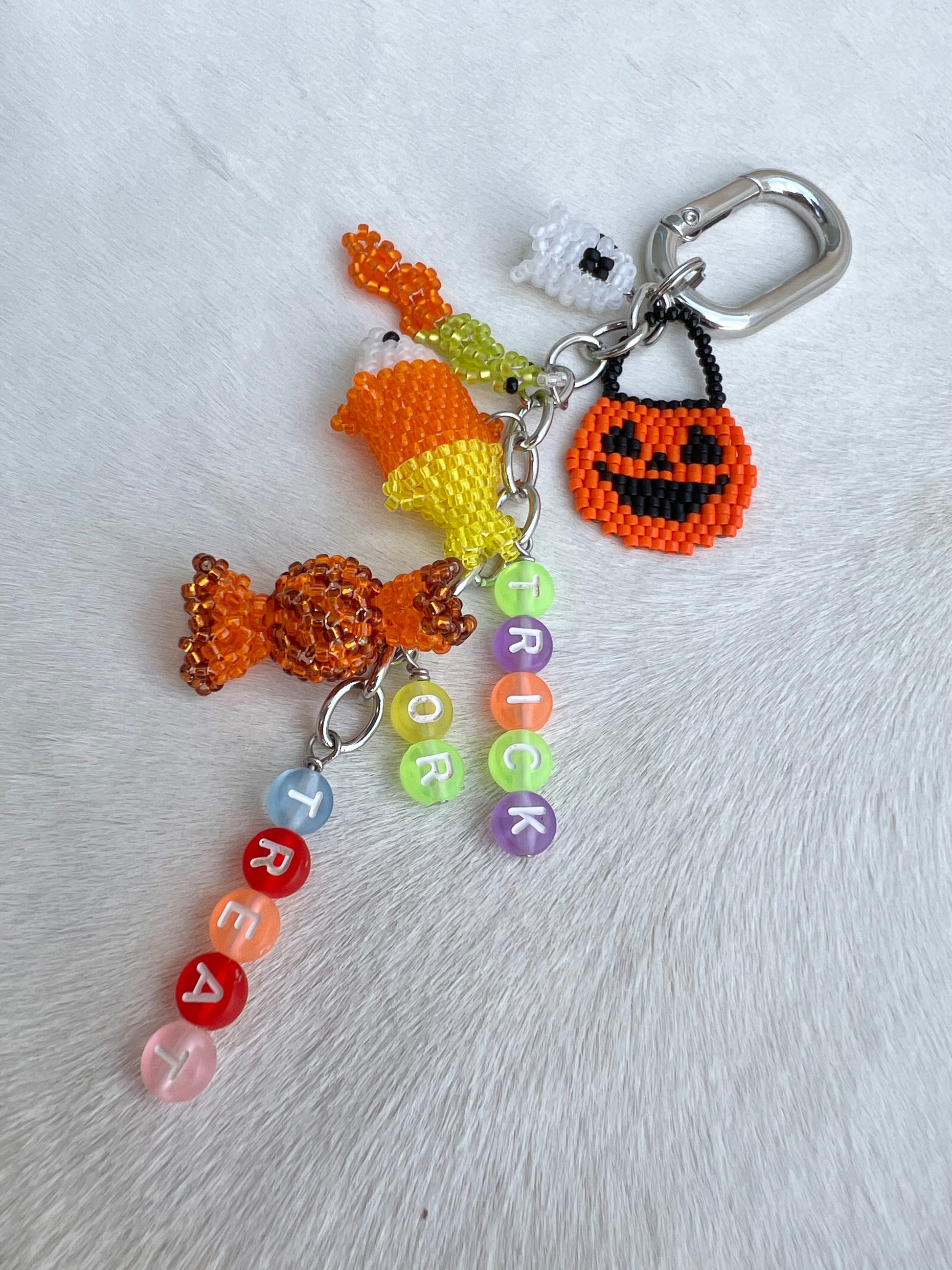 Halloween-themed keychain with candy, ghost, and pumpkin design on a white background