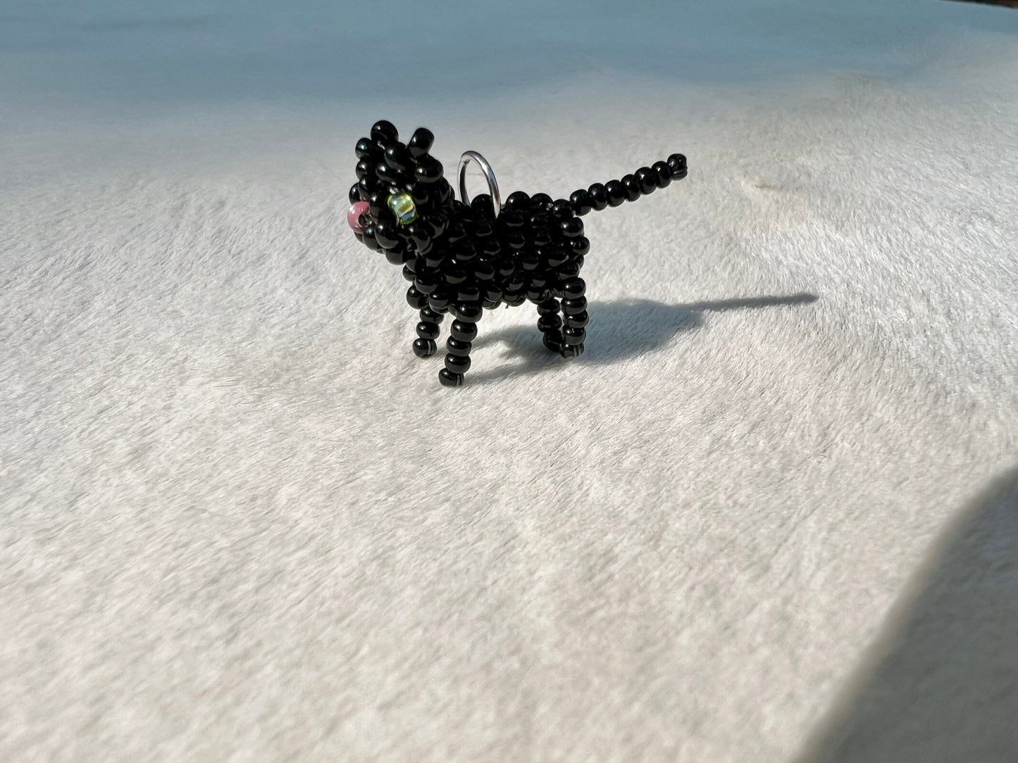 Black beaded cat figurine on a white surface