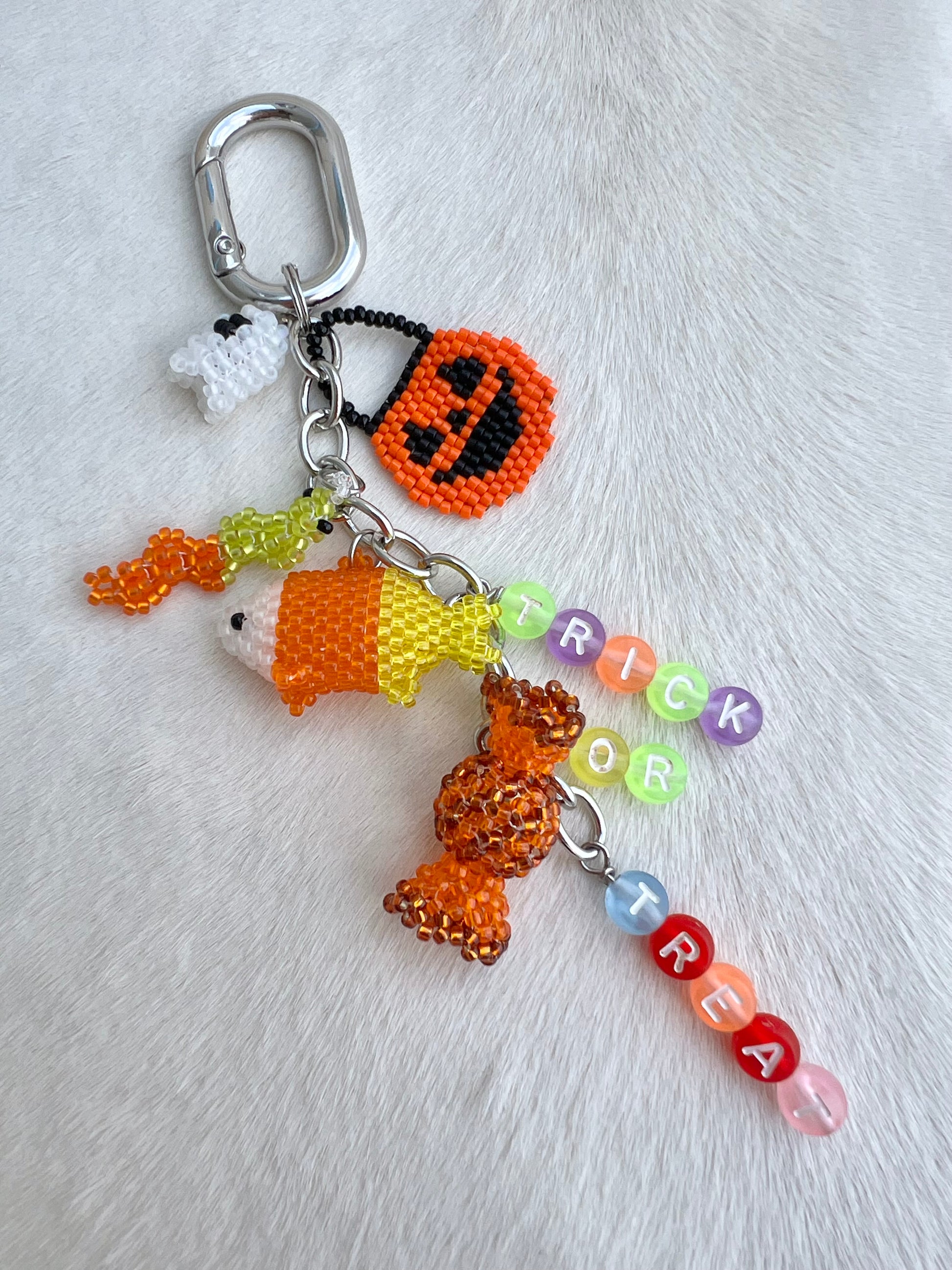 Halloween-themed keychain with beaded characters and 'Trick or Treat' letter beads on a white background