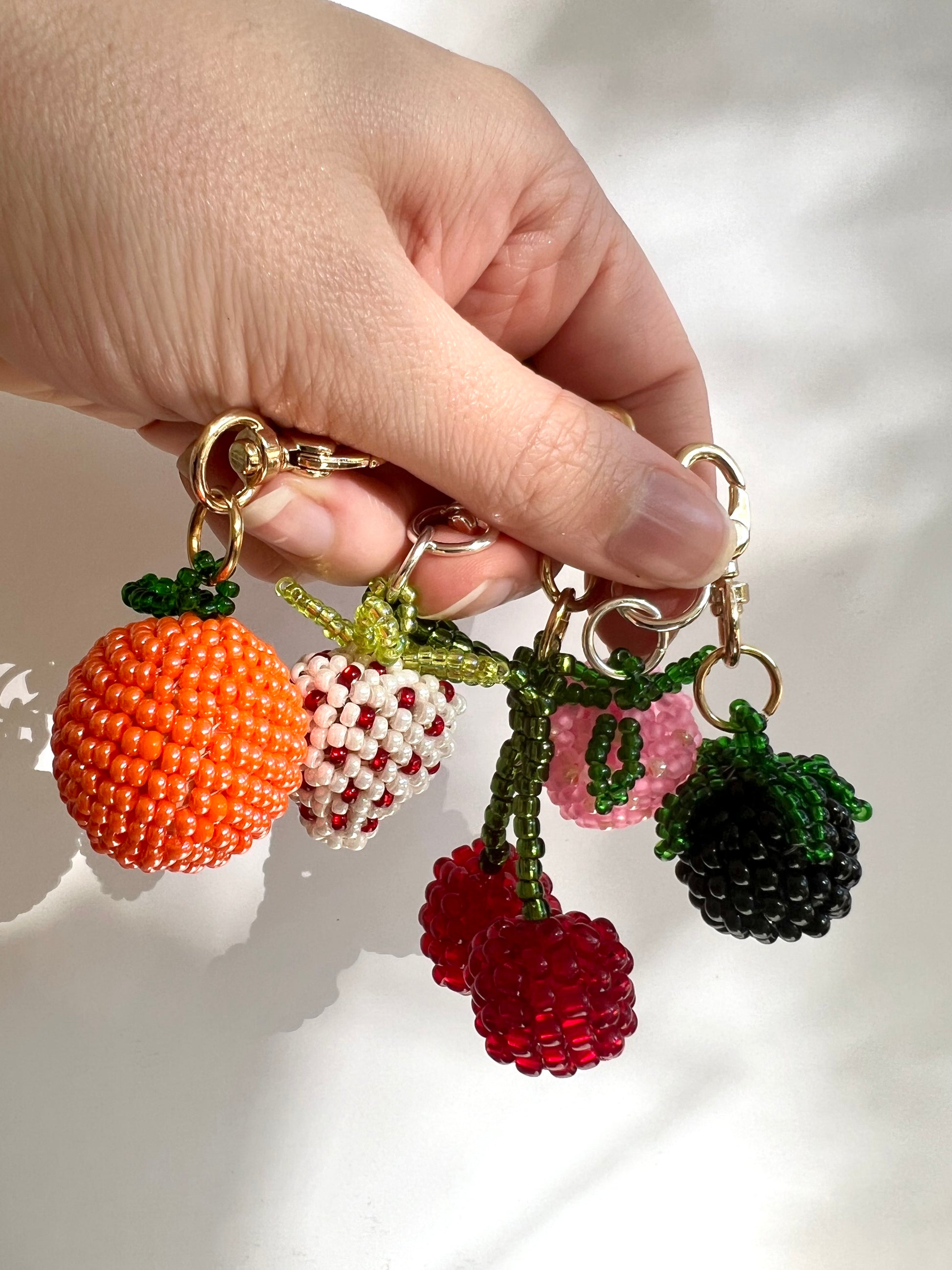 Hand beaded fruit keychains and charms.
