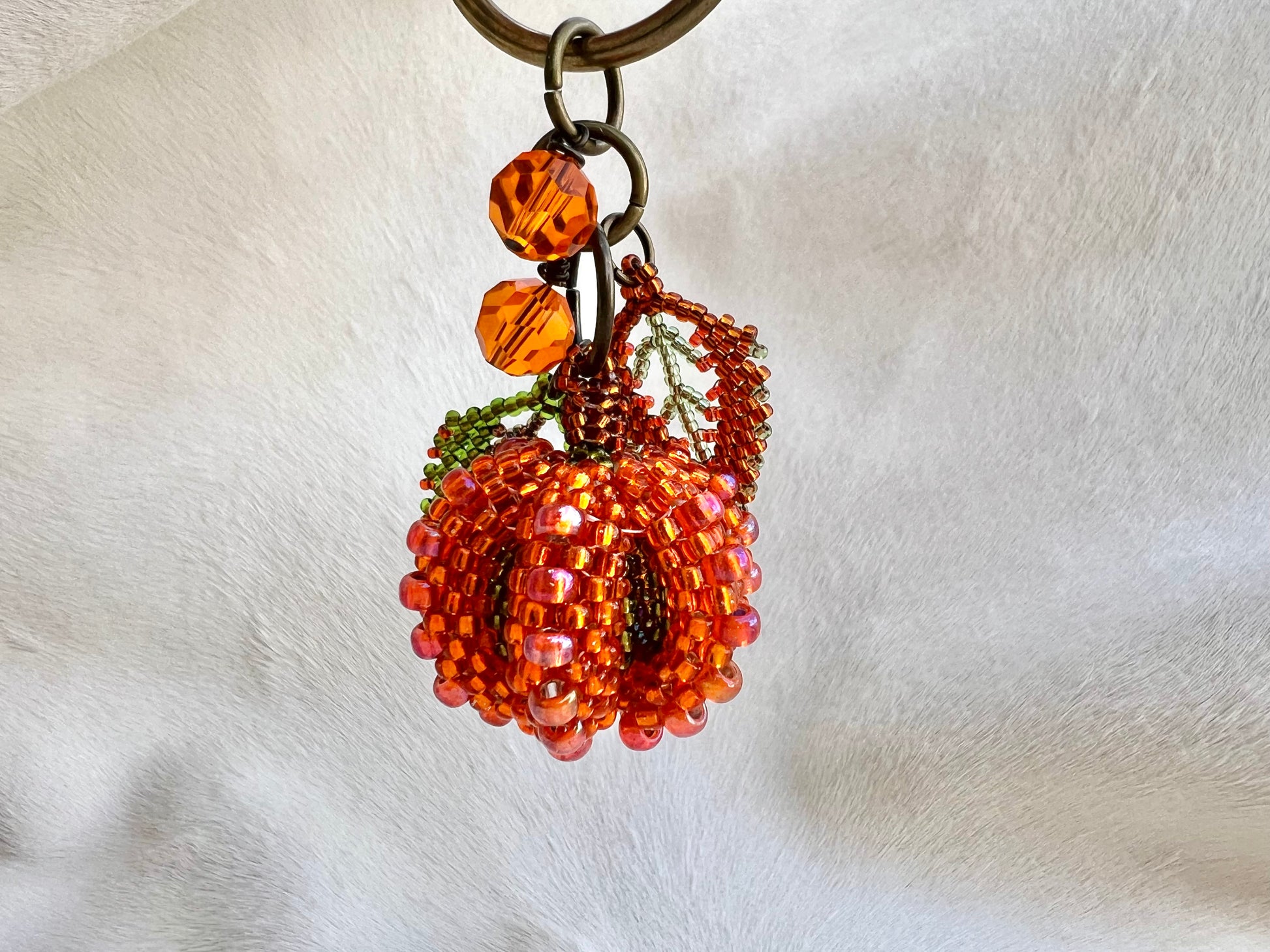 Beaded pumpkin keychain on a white background