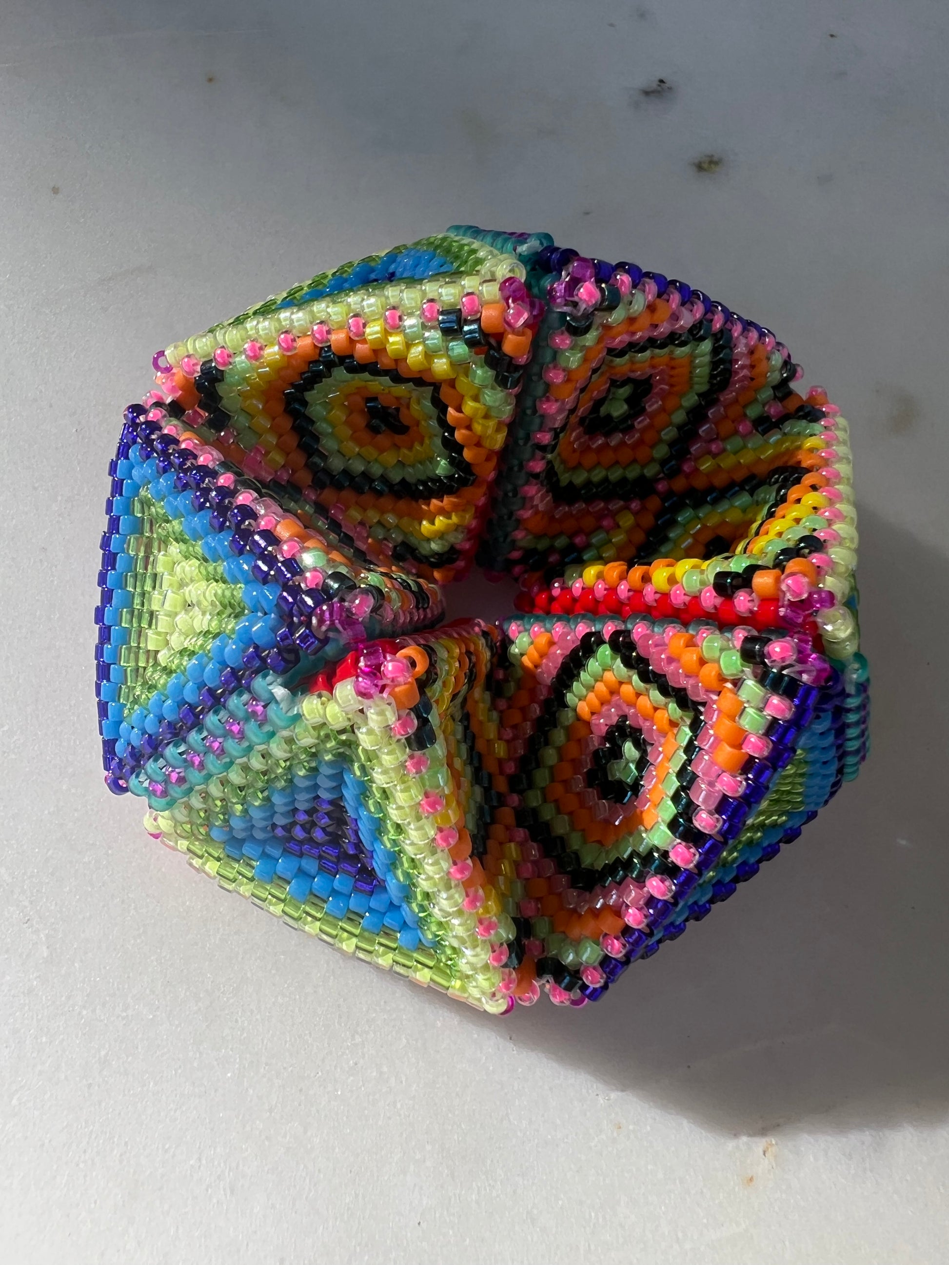 Colorful geometric bead kaleidocycle on a white background